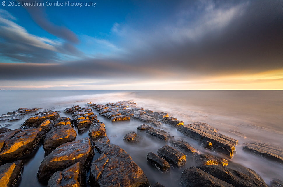 rock formation in the middle of sea HD wallpaper