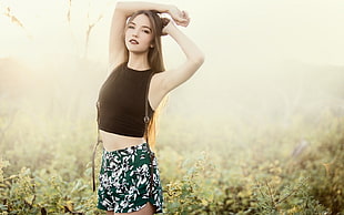 woman in black crop top and green-and-white floral shorts