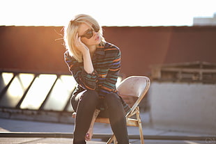 woman wearing green and blue striped long sleeve shirt sitting outside