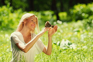 bokeh photo of butterfly on woman's hand during daytime HD wallpaper