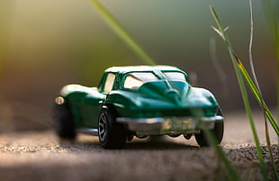 close-up photography of green classic coupe die-cast, sunset drive