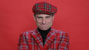 man wearing red and gray plaid top with hat