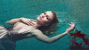 woman wearing beige satin dress floating on swimming pool photography