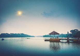 wooden gazebo with dock near water at daytime