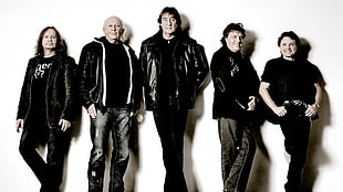 five men wearing black leather jacket standing in front of white background