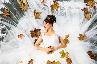 women's white lace wedding dress leaning on ground with maple leaves HD wallpaper
