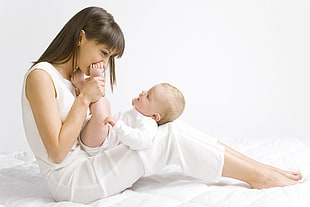 woman kissing baby's feet HD wallpaper
