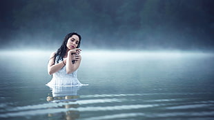 woman in white dress in body of water during daytime