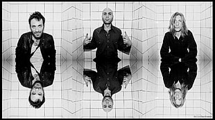 grayscale mirror effect photo of three men in black jackets