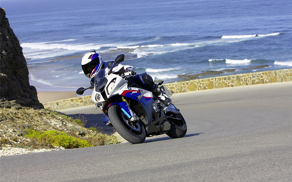 photo of man riding a white and blue sports bike during daytime HD wallpaper