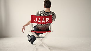 person sitting on red director chair