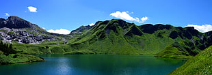 landscape photography of lake in front of mountains under blue sky