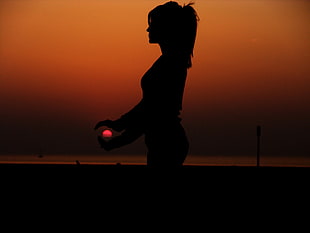 silhouette photography of woman and sun