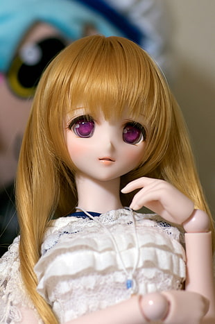 closeup photo of blonde haired woman wearing white top doll