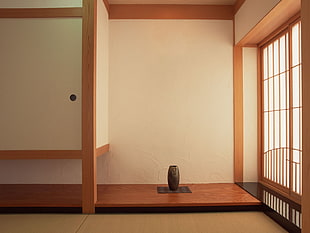 brown vase near beige painted wall