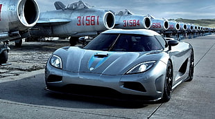 gray sports car beside the planes