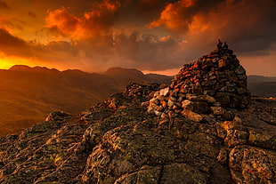rock formation near mountain during golden hour HD wallpaper