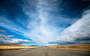 gray asphalt road between desert