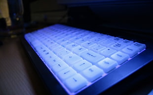 white and black computer keyboard above black surface