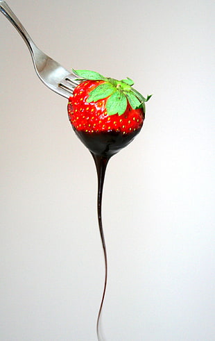 strawberry fruit dipped with chocolate syrup with silver fork