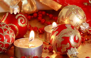 lighted candles near red and brown bauble