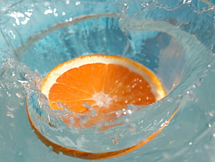 time lapse photography of sliced orange fruit splashed on water