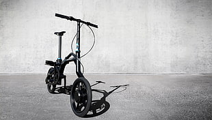 black folding bike on gray concrete pavement HD wallpaper