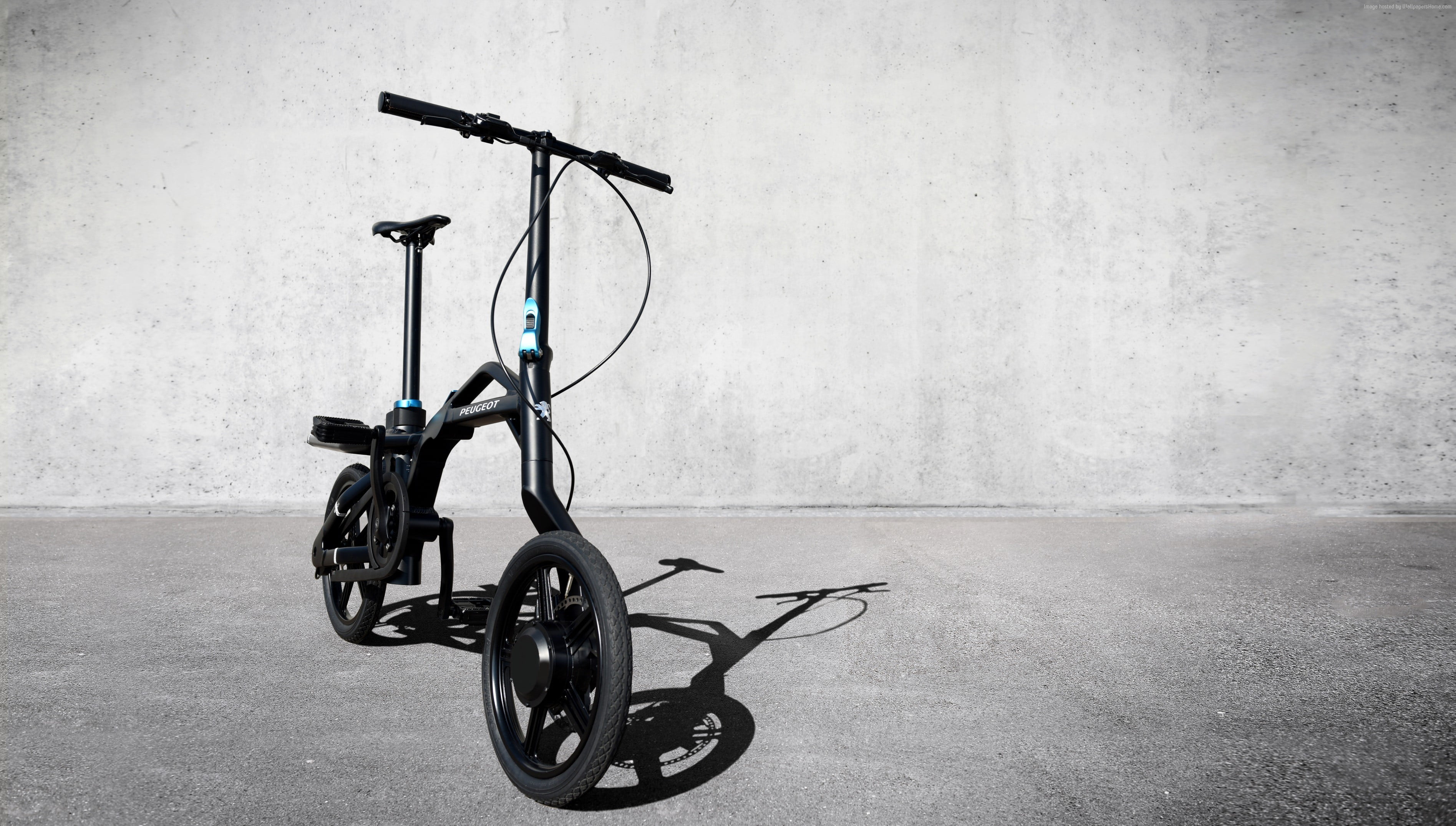 black folding bike on gray concrete pavement