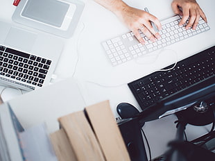 person holding silver bluetooth keyboard