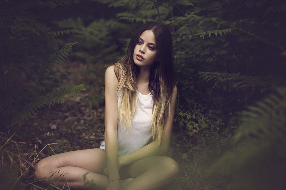 woman in white tank top sitting in a forest HD wallpaper