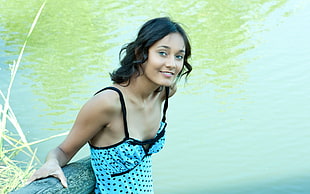 woman with blue cami top near body of water