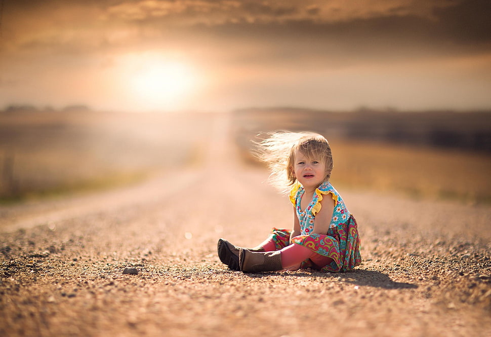 girl sitting on soil ground selective focus golden hour photography HD wallpaper
