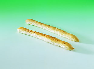 two baked breads on white surface