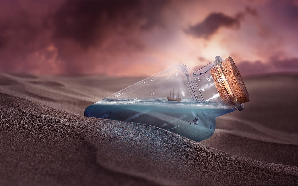 clear glass cork bottle on gray sand HD wallpaper