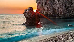 grey stone monolith, sea, rock, sunset, sun rays HD wallpaper