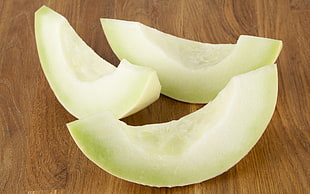 three sliced fruits on brown wooden surface