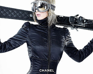 woman wearing black jacket and holding snow skis behind her back