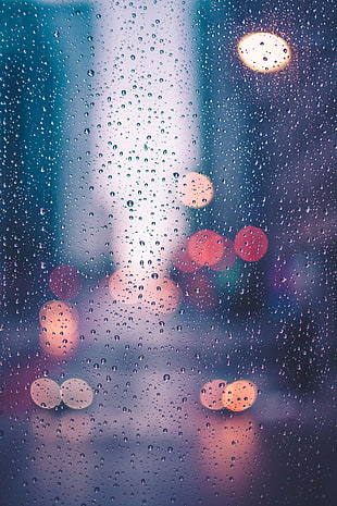 bokeh light photography of water drops on glass