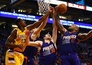 3 Phoenix suns basketball players grabbing ball against Tristan Thompson
