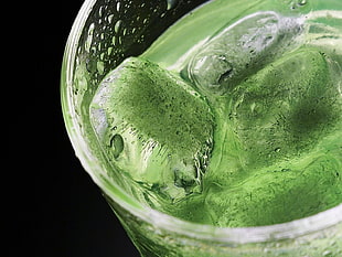 clear drinking glass filled with green liquid and ice cubes