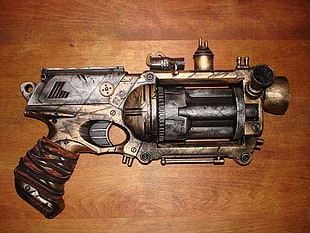 black and gold revolver gun on brown wooden board