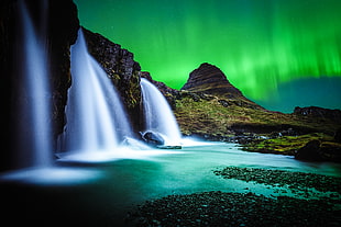 body of water falling from above during green sky HD wallpaper