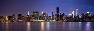 city high-rise buildings near calm body of water at night time, queens HD wallpaper