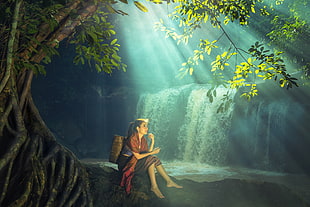 woman carrying basket sitting on rocky shore near waterfalls with light streaks during daytime