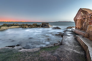 brown rock formation near body of water during daytime photo, sandycove, dublin, ireland