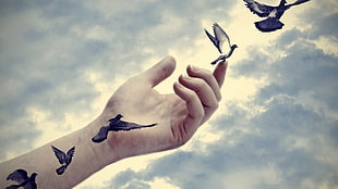 flying doves hand tattoo with clouds background