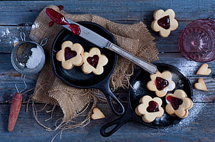 two round non-stick frying pans with butter knife and containers