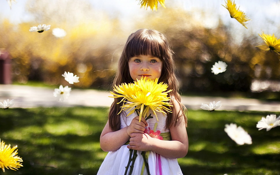 selective focus photography of girl holding yellow petaled flower during daytime HD wallpaper