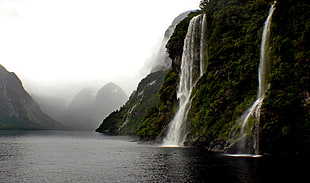 photo of mountain's waterfall dropped on body of water HD wallpaper