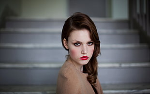 selective focus photography of woman in red lipstick and brown top